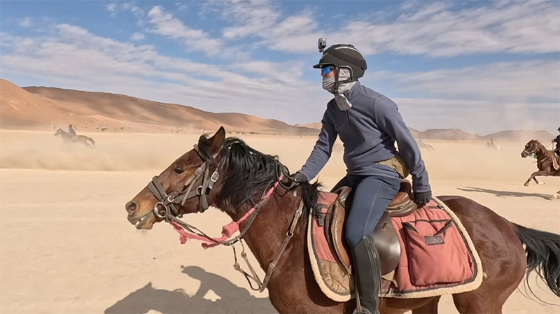 Cavalière au galop dans un désert de sable