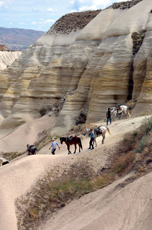 Groupe de cavalier marchant avec leur chevaux en main en Cappadoce