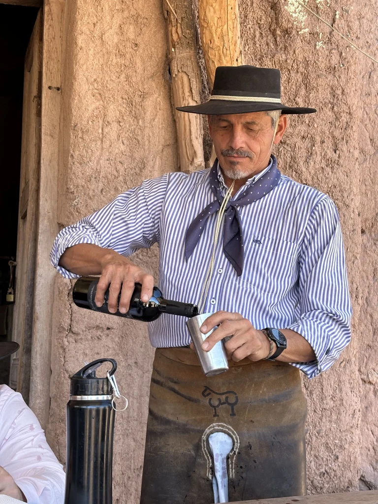 un gaucho en argentine en tenue traditionnelle qui verse du vin dans verre