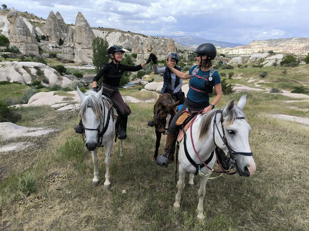equipe de cavaliers qui se tapent dans la main lors du jeu équestre the great cappadocian ride en turquie