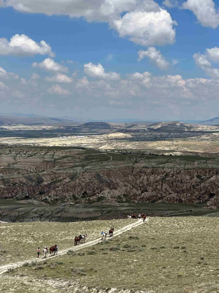 des cavaliers dans l'immensité des plateaux de cappadoce en turquie