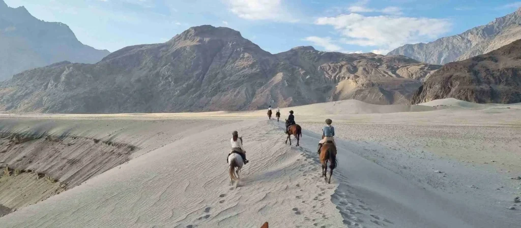 un groupe de cavaliers qui avance à cheval dans le desert de sarfaranga dans le nord du pakistan